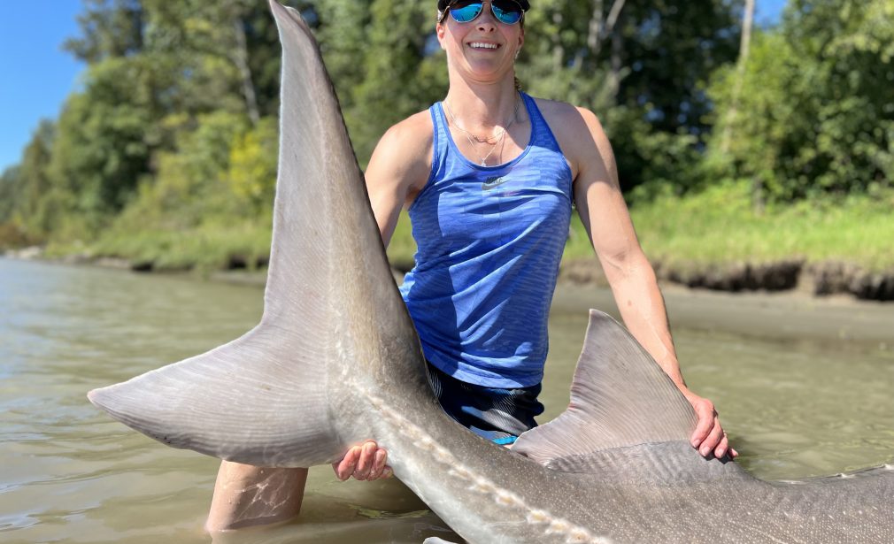 Woman holding a giant Sturgeon Tail