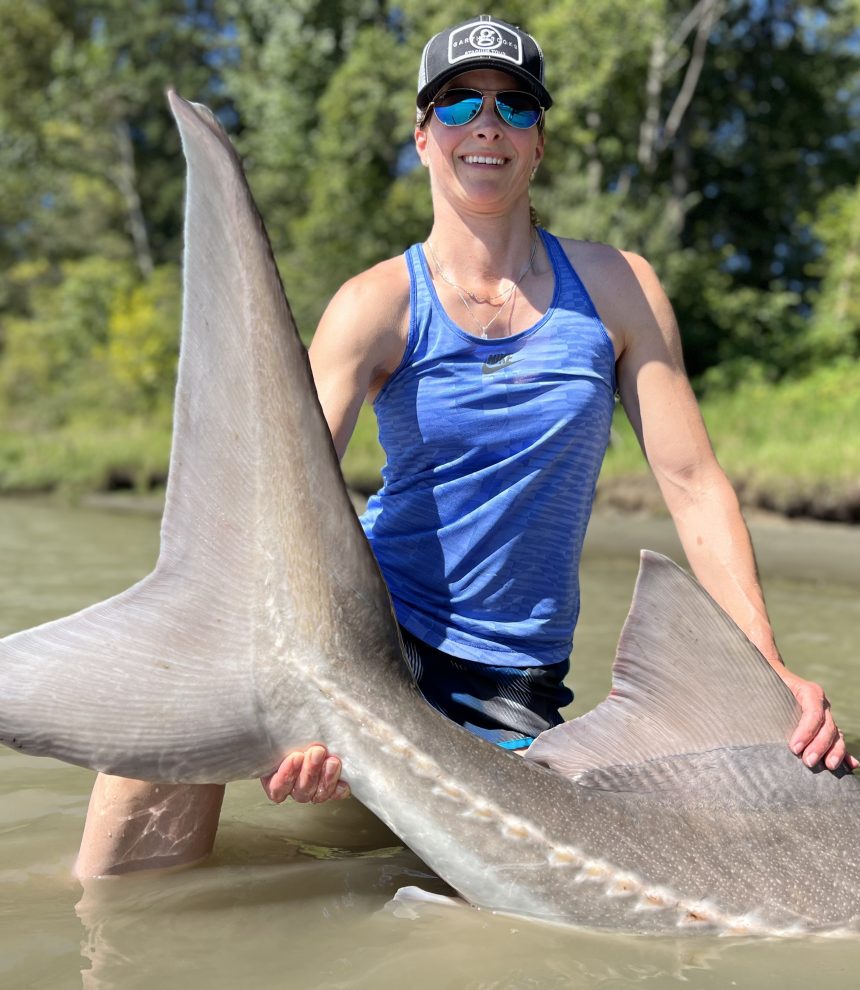 Woman holding a giant Sturgeon Tail